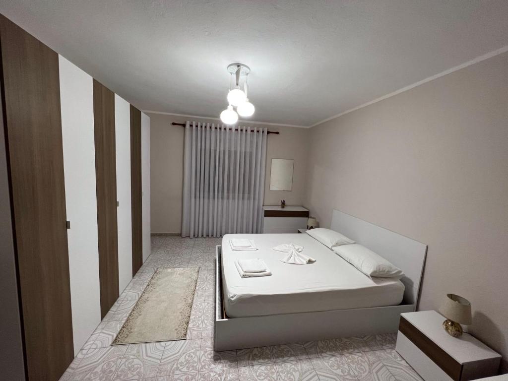斯库台Home Shkodra Center的一间白色卧室,卧室内配有一张床