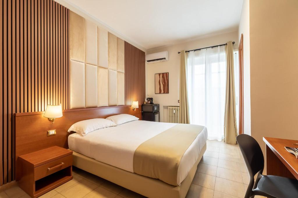 罗马AlbaDomus Affittacamere的酒店客房设有一张大床和一张书桌。
