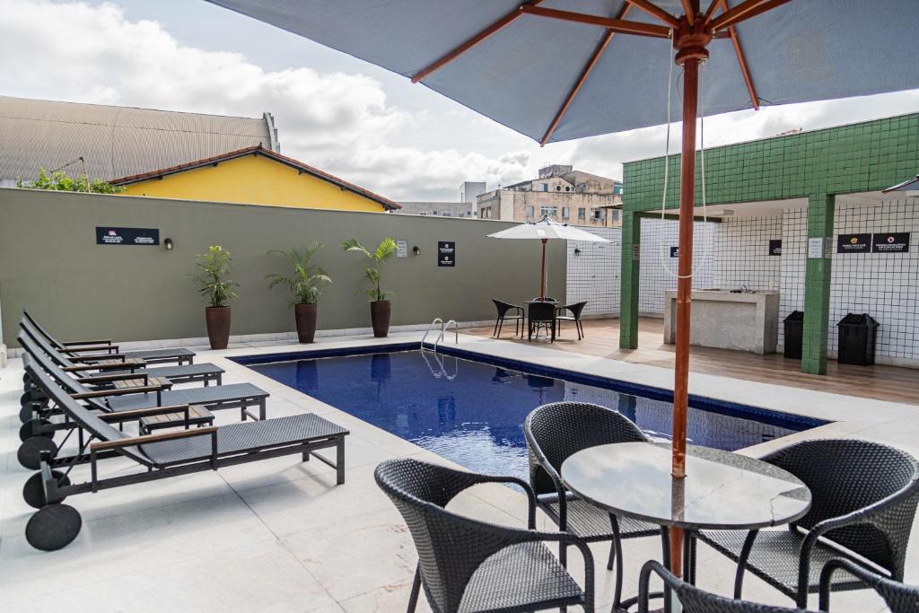 孔塔任Hotel Eldorado Flat的一个带桌椅的庭院和一个游泳池