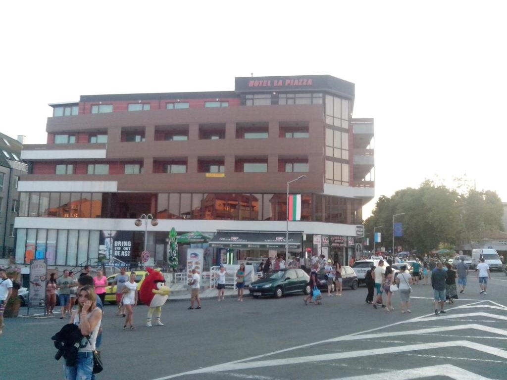 普里莫尔斯科La Piazza Primorsko Rooms & Apartments的一群人穿过大楼前的街道