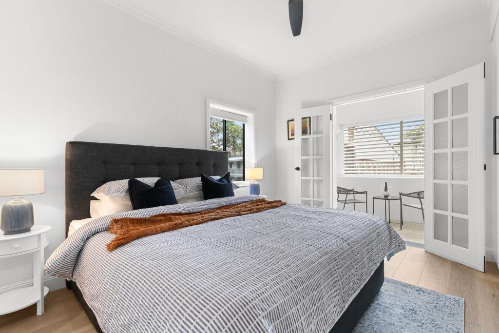 悉尼Hamilton Lodge的白色卧室配有一张蓝色地毯的大床