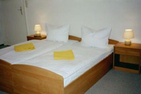 柏林佩西恩婚礼酒店的一间卧室配有一张带两张黄色毛巾的床