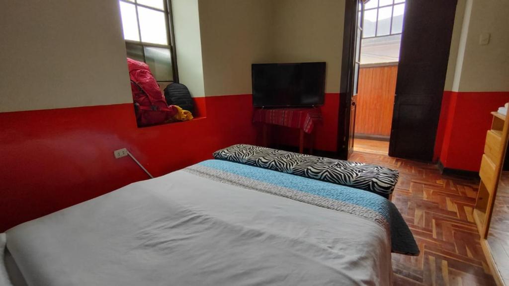 塔尔马Hospedaje Colonial Tarmeño.的一间卧室配有一张床和一台平面电视