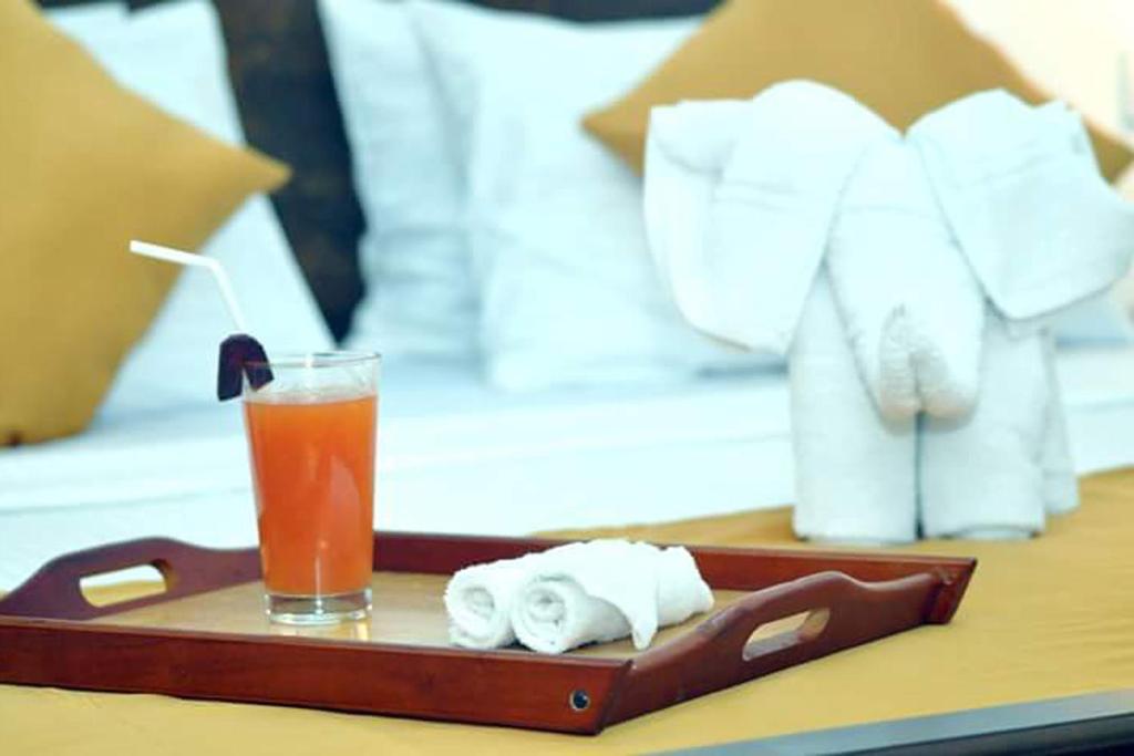 达瓦拉维Green View Safari Paradise的托盘,带毛巾和桌子上的饮料