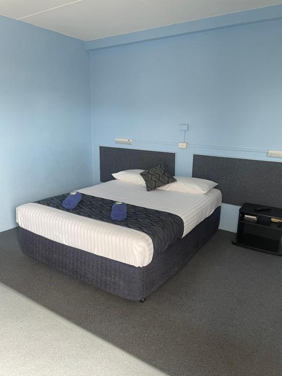 SpringsureSpringsure Hotel Motel的一张大床,位于一个蓝色的墙壁内