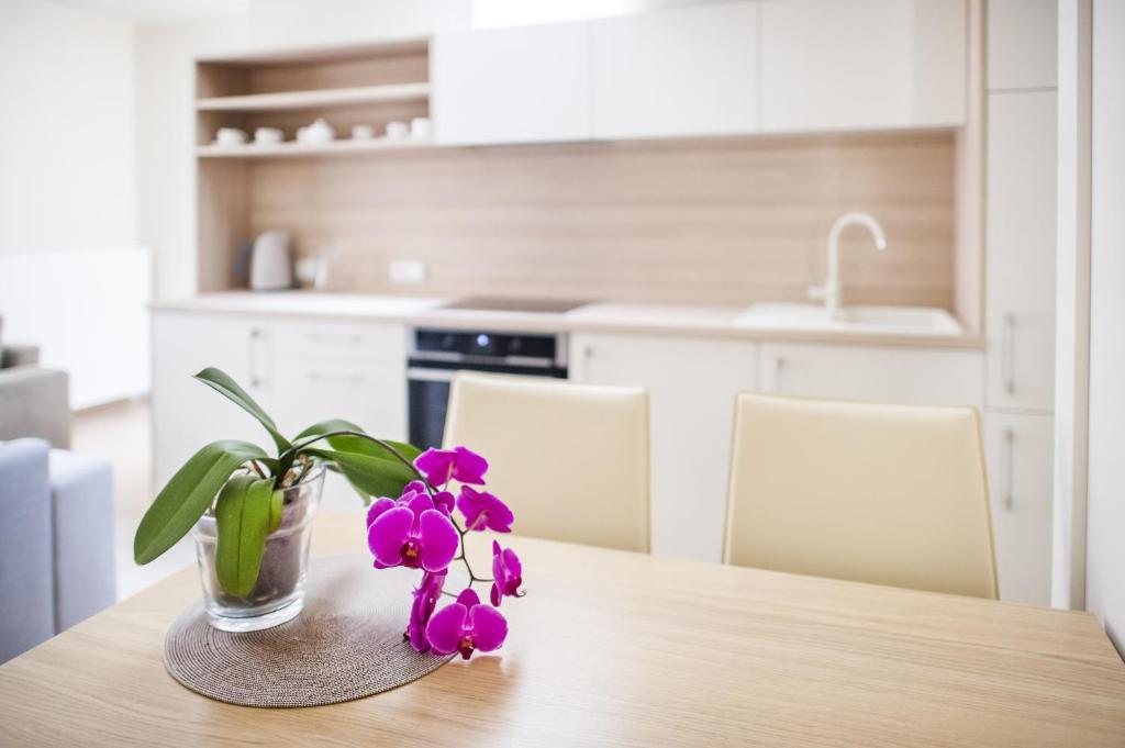 帕兰加Home of Health and Beauty的厨房里一张桌子上装着紫色花的花瓶