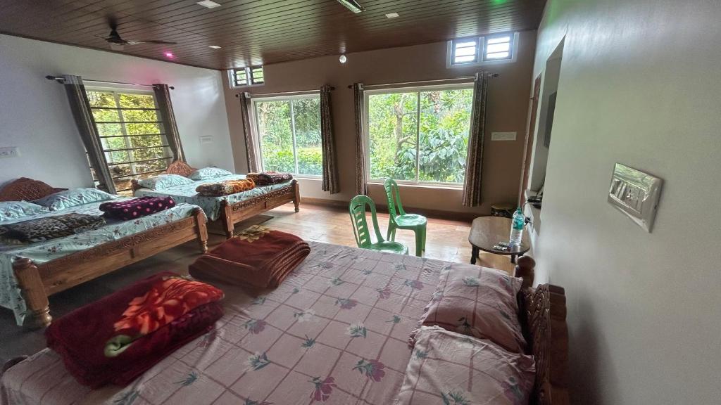 SomvārpetHomestay In Coorg Doddakallu Betta的一间带两张床的卧室和一间带窗户的房间