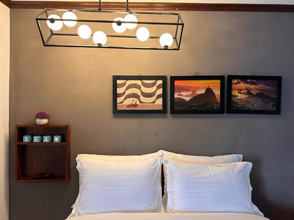 克萨尔特南戈Brazilian Art & Free Parking - emitimos factura的卧室配有一张墙上三幅照片的床