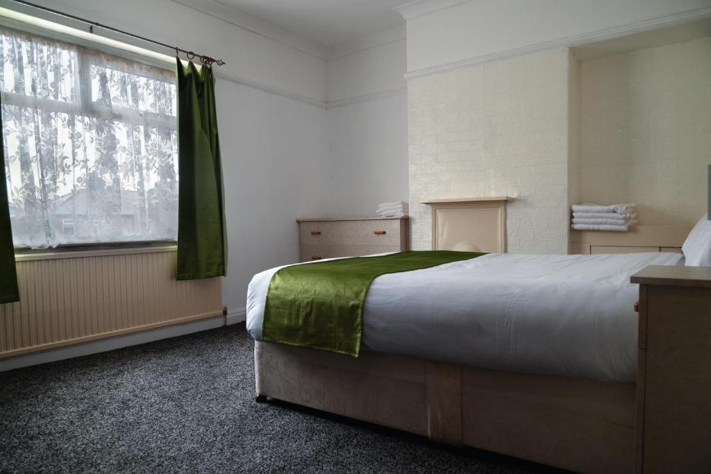 普雷斯顿Amarillys Guest House的一间卧室设有一张大床和一个窗户。
