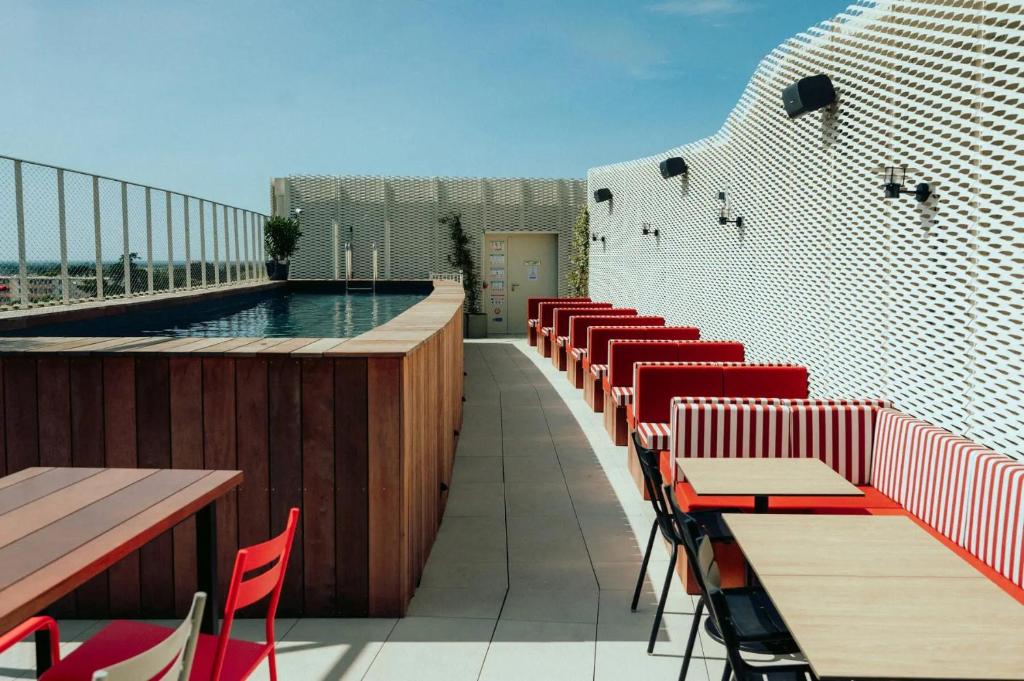 蒙彼利埃JOST Auberge de jeunesse Montpellier Centre St Roch的一个带桌椅的阳台和一个游泳池