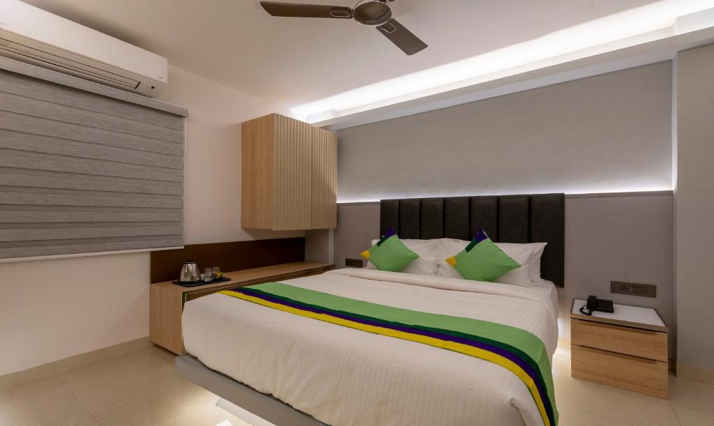 海得拉巴Treebo Tryst D Consulate的一间卧室配有一张带绿色枕头的大床