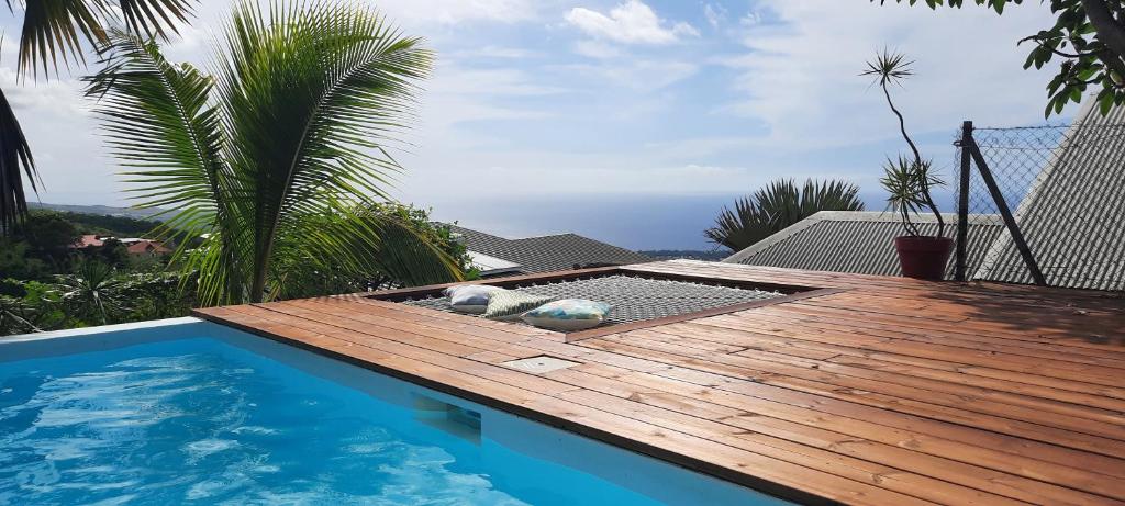 BellemèneBungalow cosy avec piscine surplombant l'océan的游泳池旁的木甲板