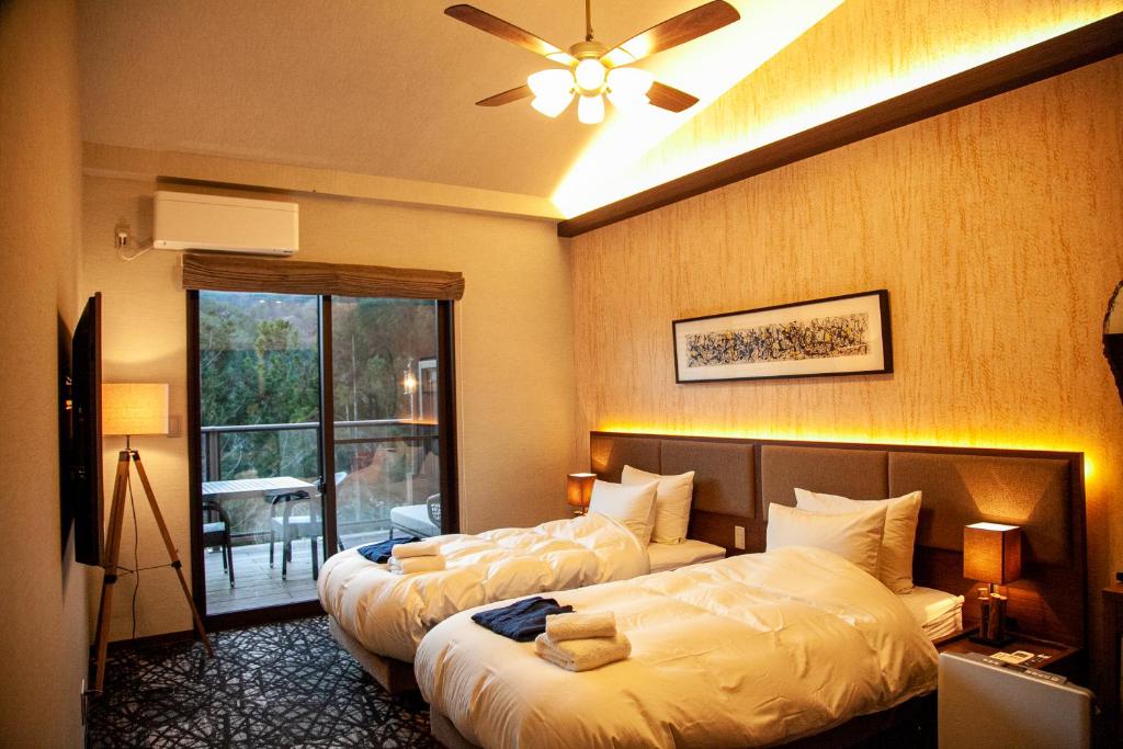 饭田市ホテル風の山的酒店客房设有两张床和一个阳台。