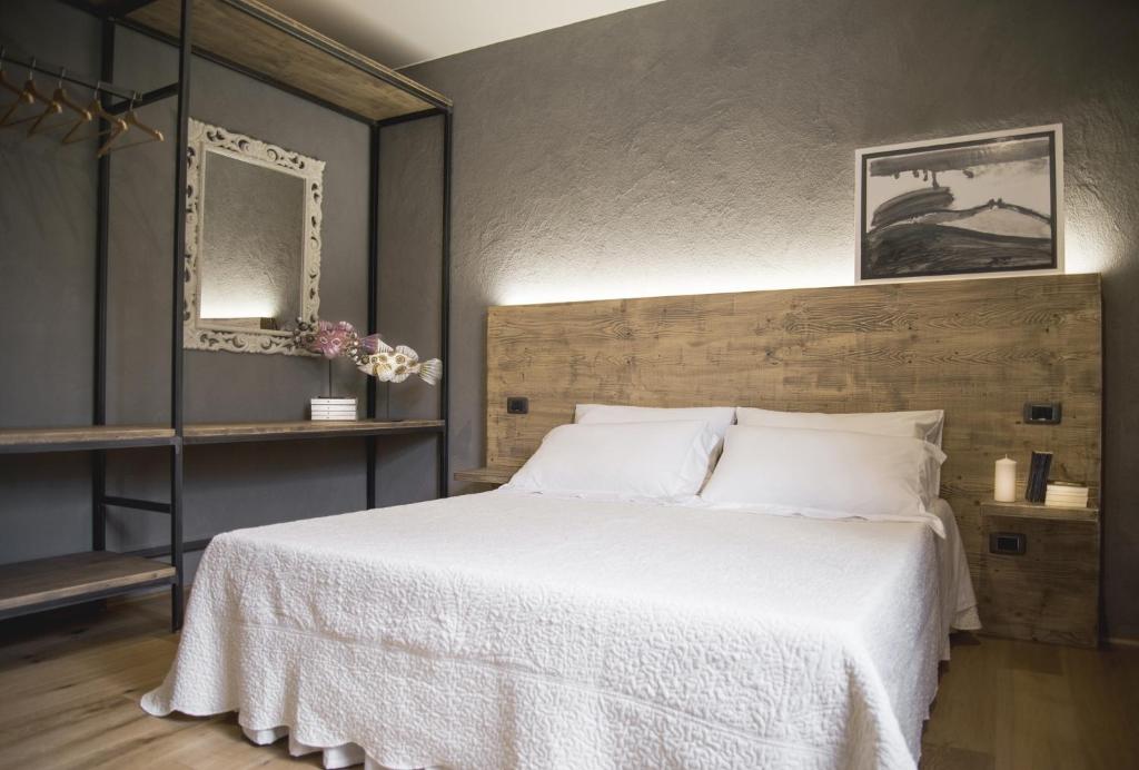比恩帝纳Il Giardino di Ortensia B&B的一间卧室配有一张带白色床单的大床