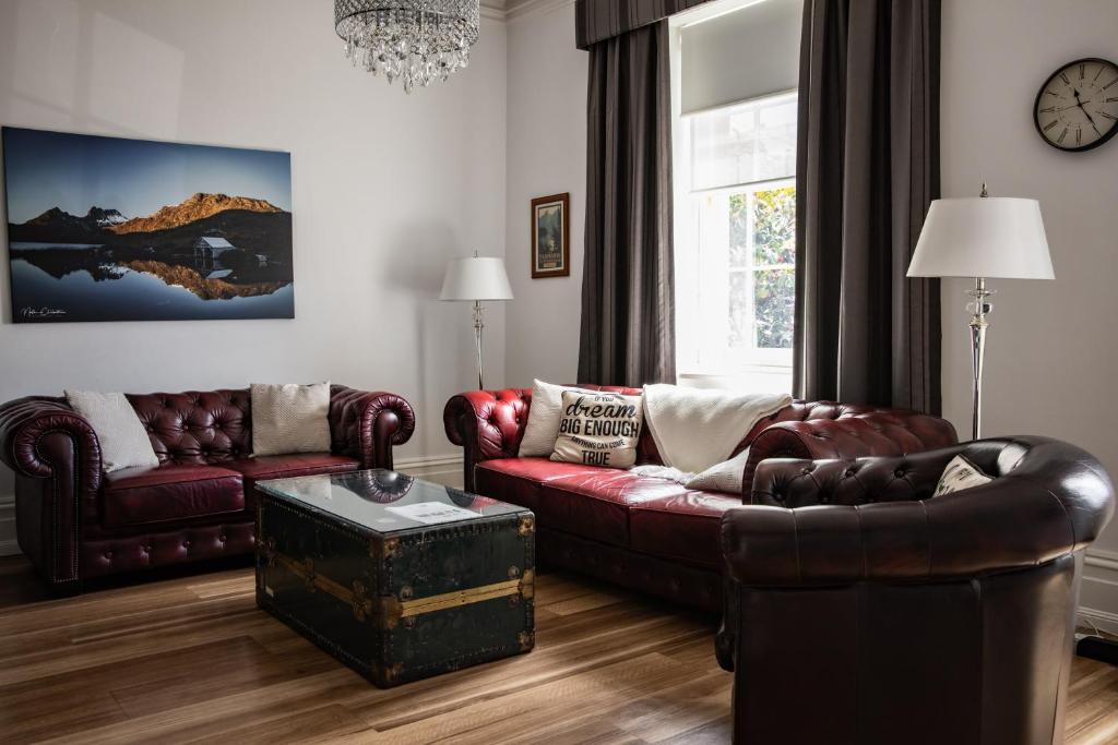 霍巴特圣殿精品公寓的客厅配有两张真皮沙发和一张桌子