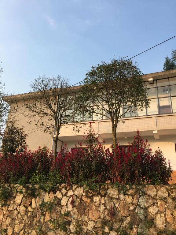 湘潭Youbao House的前面有树木和鲜花的建筑