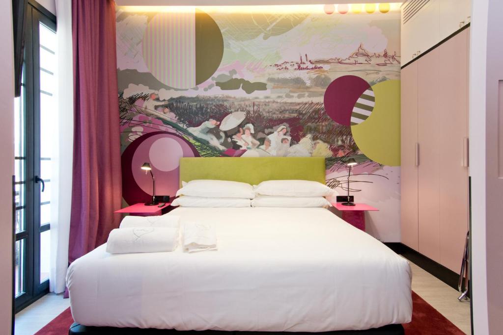 马德里Amor de Dios 17 Luxury Suites的卧室配有一张白色大床,墙上挂有绘画作品