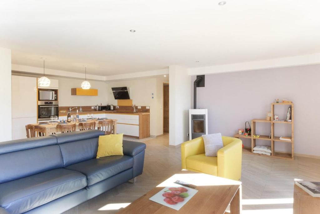 里雾诗L'Abeille - Renovated - 4 bedroom - 8 person-110sqm - Views!的一间带蓝色沙发的客厅和一间厨房