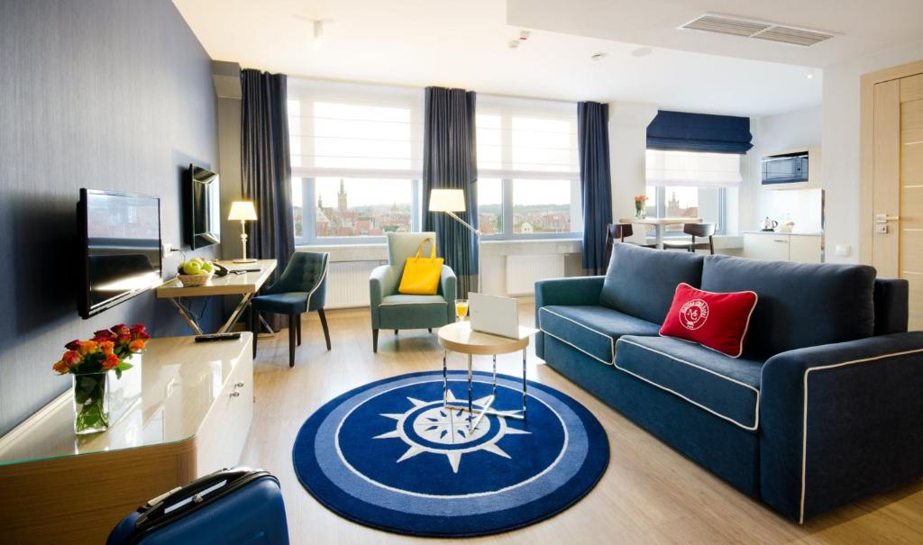格但斯克Hotel Marina Club Old Town View的客厅配有蓝色的沙发和桌子
