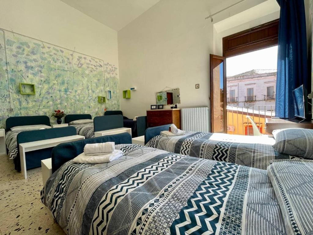 克罗托内Casa di Chiara的带四张床和沙发的客房