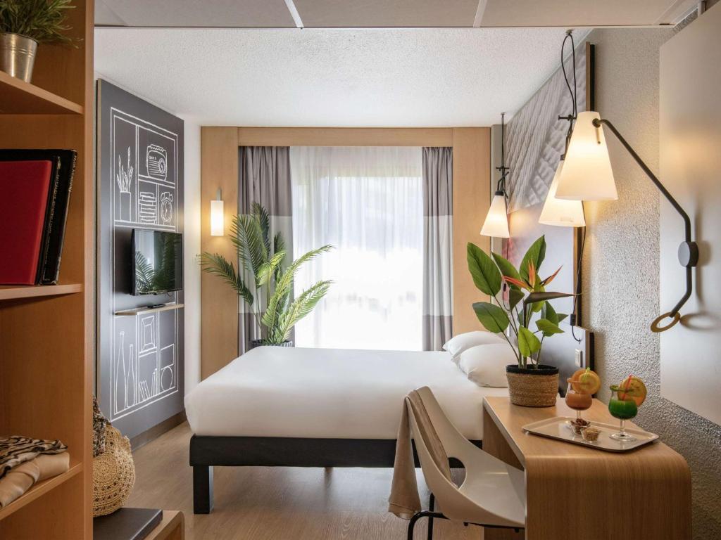 戛纳戛纳普拉基拉博卡宜必思酒店的配有一张床、一张书桌和一扇窗户的酒店客房