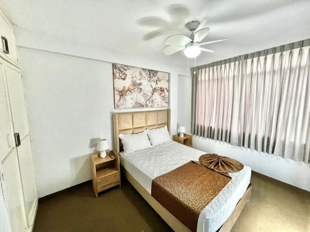 伊洛Costa Bella的一间卧室配有一张床和吊扇