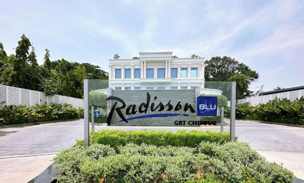 钦奈Radisson Blu Hotel GRT, Chennai International Airport的白色建筑前的标志