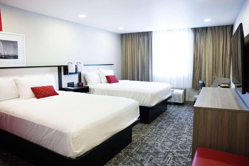 欧文Ramada by Wyndham DFW Airport的酒店客房配有两张床和一张书桌