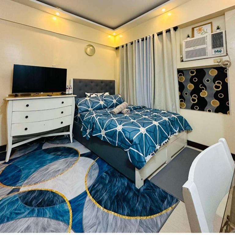马尼拉Mariz Cozy and Elegant room的一间卧室配有一张床、一个梳妆台和电视。