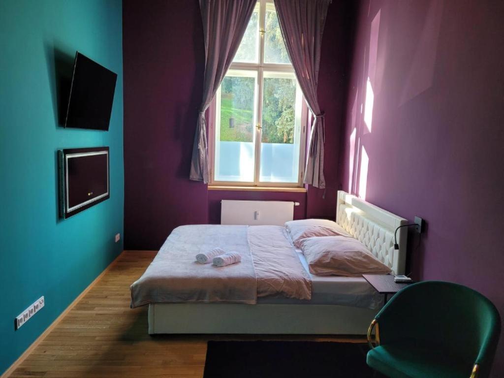 布拉格SPA SPA Apartments Vyšehrad的一间卧室配有一张紫色墙壁和窗户的床