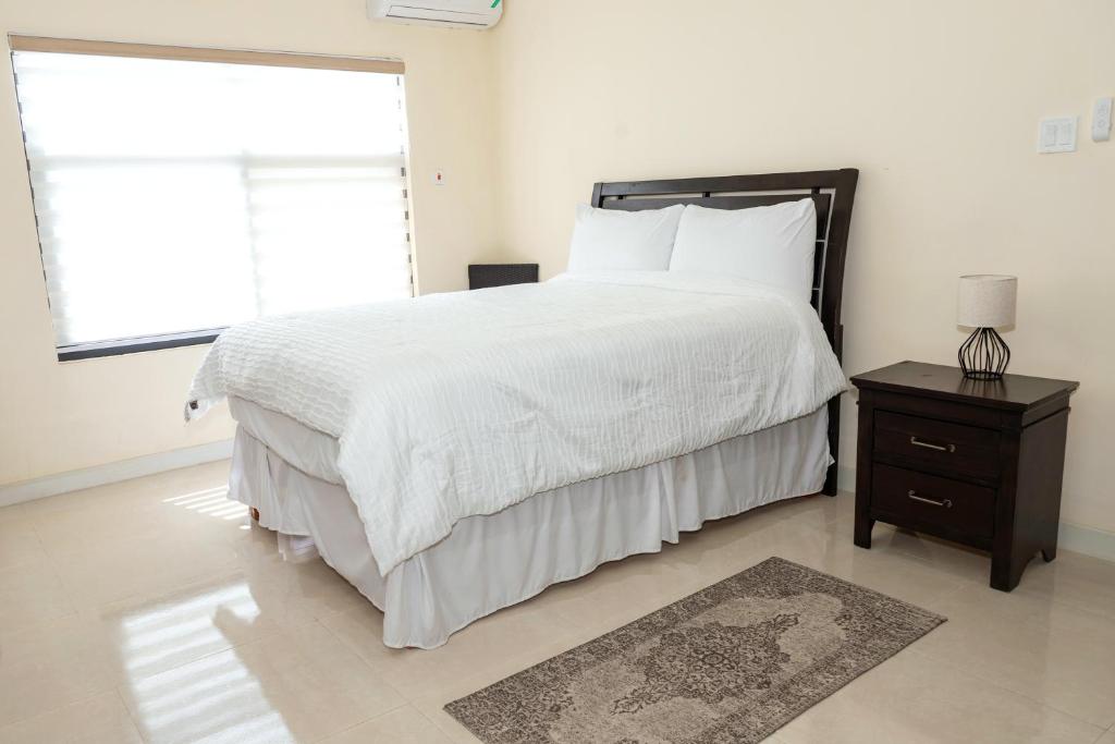 欧丘里欧Ms. T's Paradise @ Pyramid Point的卧室设有一张白色大床和一扇窗户。