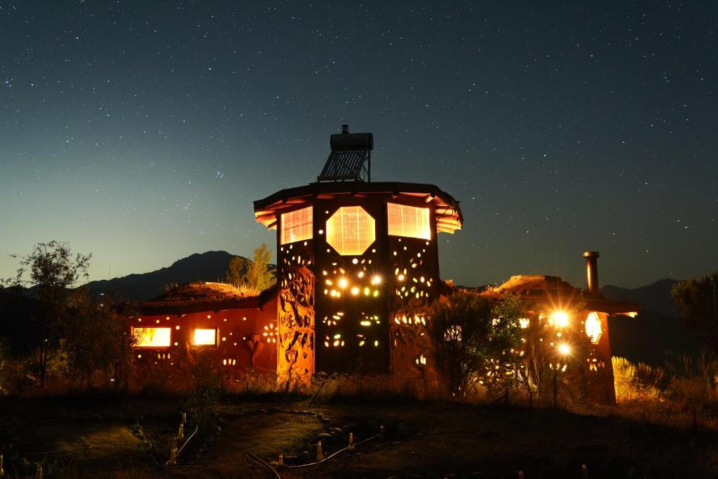 奥尔穆埃Swiss Eco Lodge La Linda Loma - Olmué的一座灯光明亮的建筑,晚上有灯