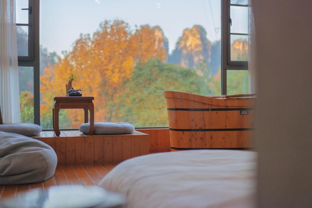 张家界Mount View Cottage的一间卧室设有一张床和一个大窗户