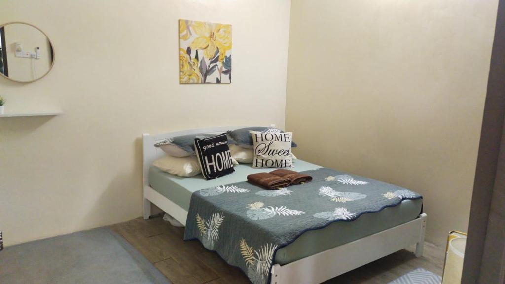 金宝Teratak Hannani Maryam Kampar ( Muslim Homestay)的一间卧室配有带枕头的床