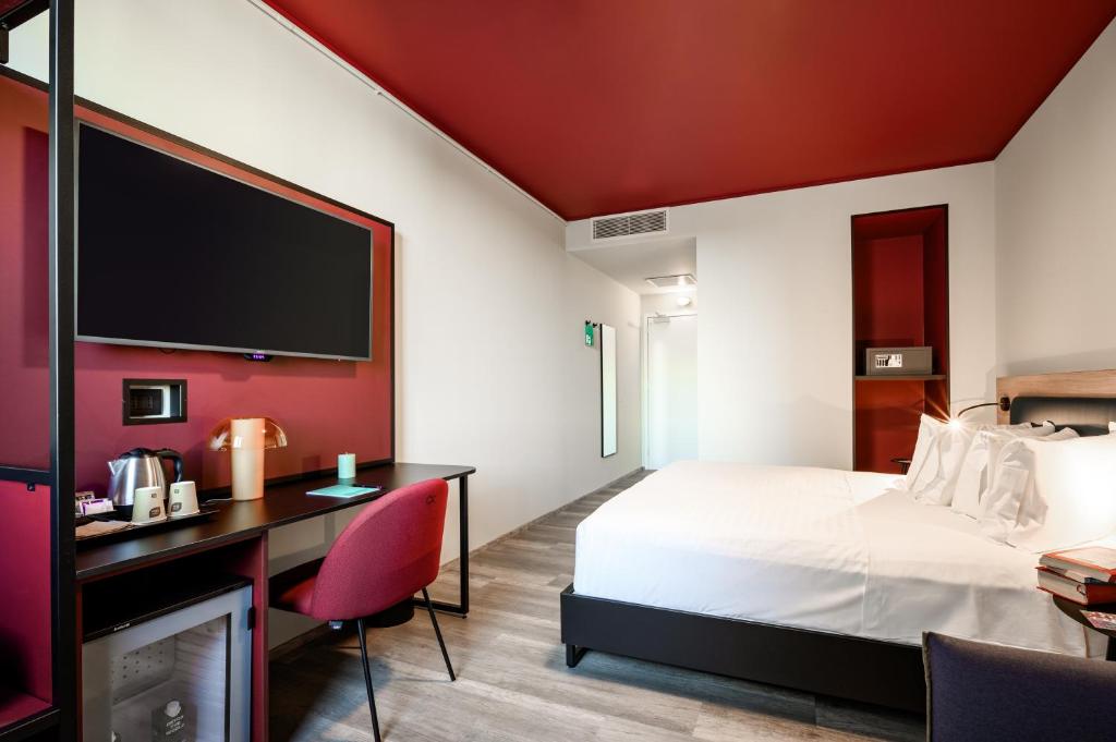 梅斯特CX Venice Mestre的酒店客房设有一张床、一张书桌和一台电视机。