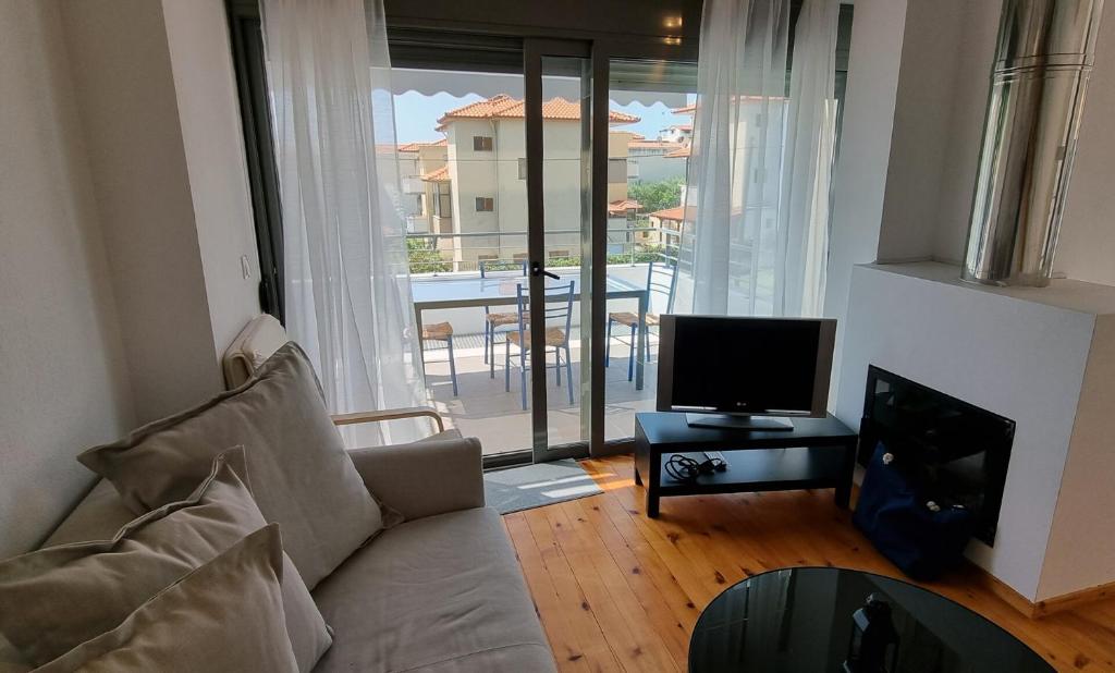 梅塔诺佛希斯Cozy Beach Apartment Dimitrios的带沙发和平面电视的客厅