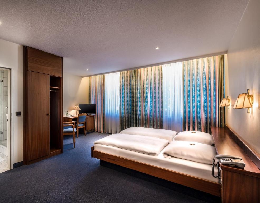 汉堡Hotel Alte Wache的一间卧室配有一张大床和一张书桌