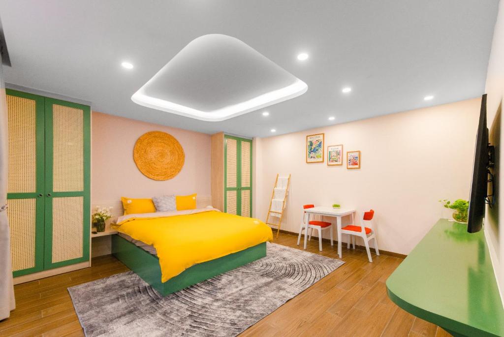 芽庄Pavillon Garden Hotel & Spa Nha Trang的一间卧室配有一张黄色的床和一张桌子