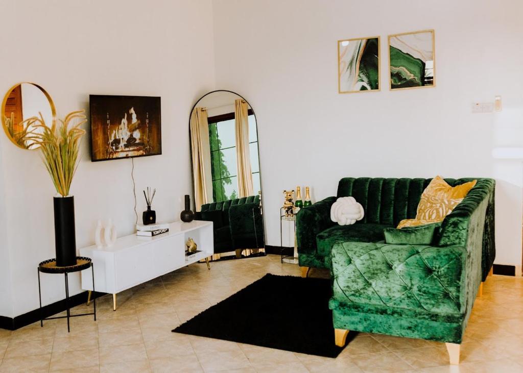达累斯萨拉姆LM Apartments的客厅配有绿色沙发和镜子
