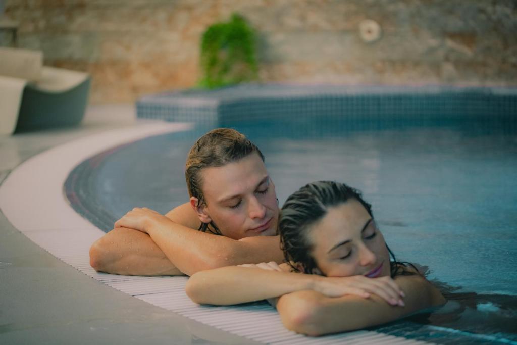 加尔达湖滨Astoria Resort的两个年轻的女人躺在游泳池里