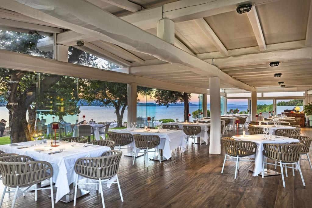 巴哈撒丁岛拉罗卡度假酒店及spa 的一间设有白色桌椅的海洋餐厅