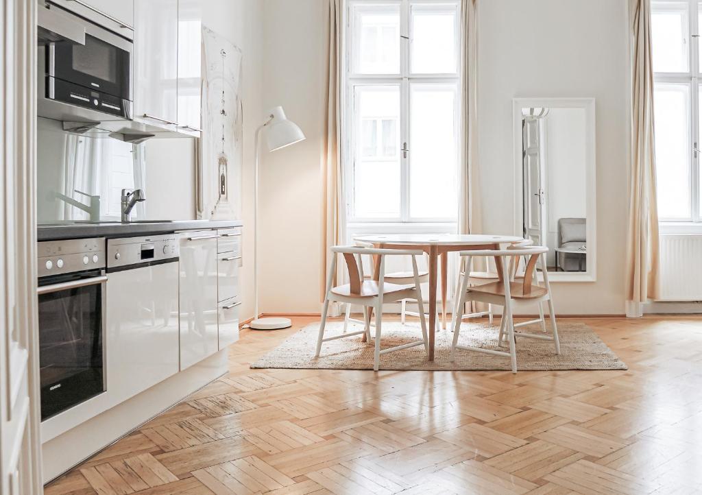 维也纳HeyMi Apartments Stephansdom的白色的厨房配有桌椅