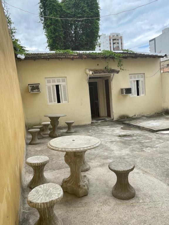 坎普斯戈伊塔卡济斯Status Casa Pelinca的一组桌子和凳子在建筑物前