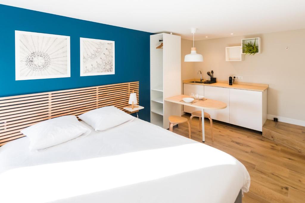 斯特拉斯堡Studios de la Nuée Bleue的卧室配有白色的床和蓝色的墙壁