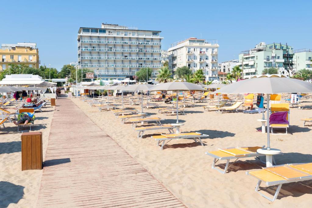 里米尼Hotel Centrale Miramare的沙滩上设有躺椅和遮阳伞