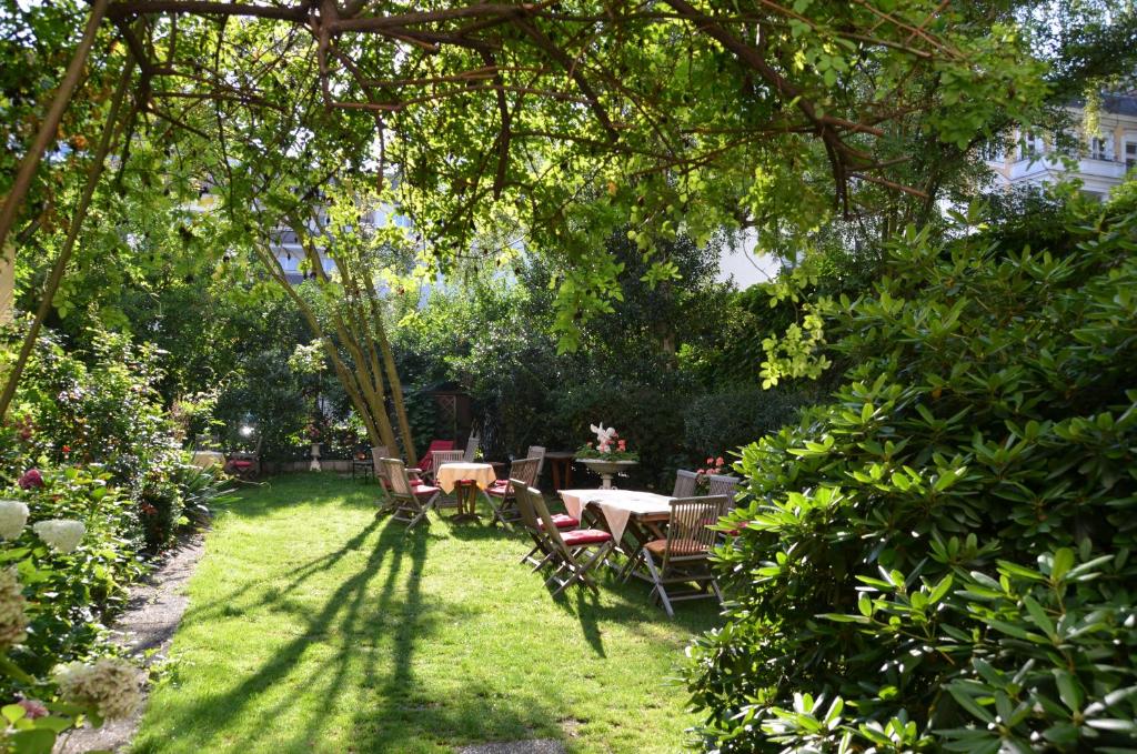 柏林柏林达斯利特拉特酒店的树下带桌椅的花园
