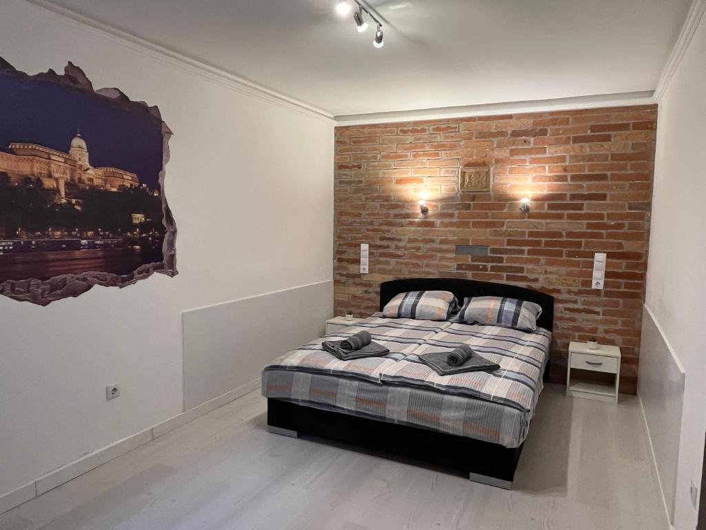 布达佩斯Fancy home Budapest的砖墙房间的一个床位