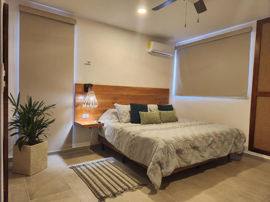 梅里达Las Huayitas, by Casa Amaranto的一间卧室配有一张带木制床头板的床