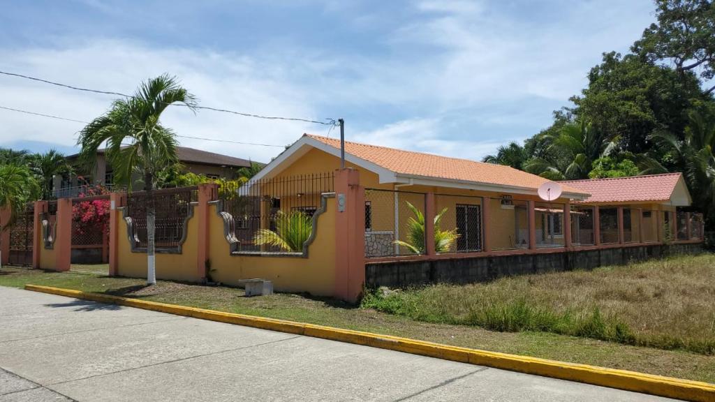 科尔特斯港Casa en la playa puerto cortes的街道边的黄色小房子