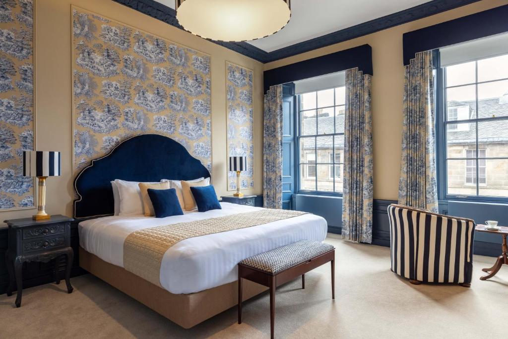 爱丁堡Eleven Stafford Street Townhouse的一间卧室设有一张大床,拥有蓝色的墙壁和窗户。